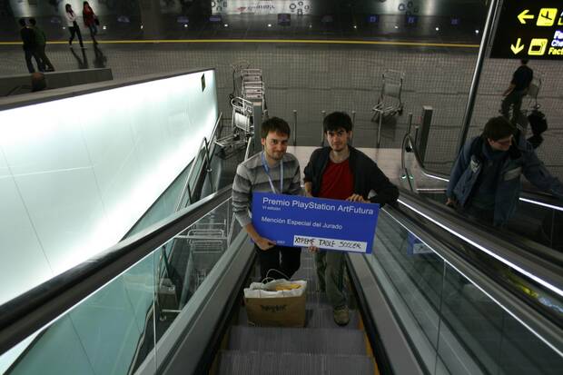 Alejo Acevedo y Enrique Cabeza posan con el cheque de Art Futura por el primer juego que el equipo terminó como equipo amateur, un futbolín.